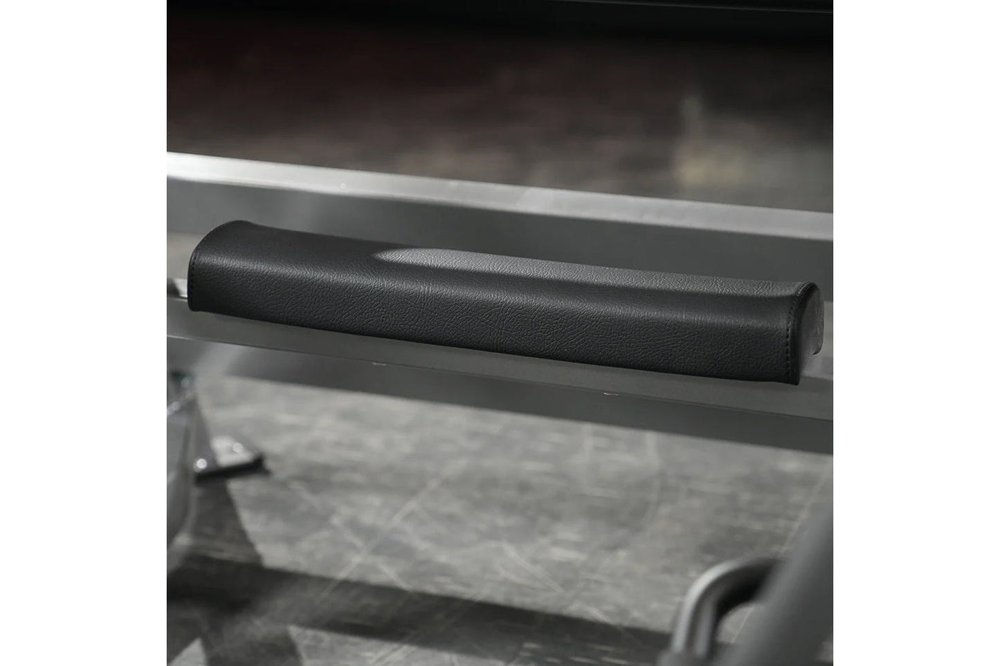 Black leather handle pad on gray metal frame of squat machine