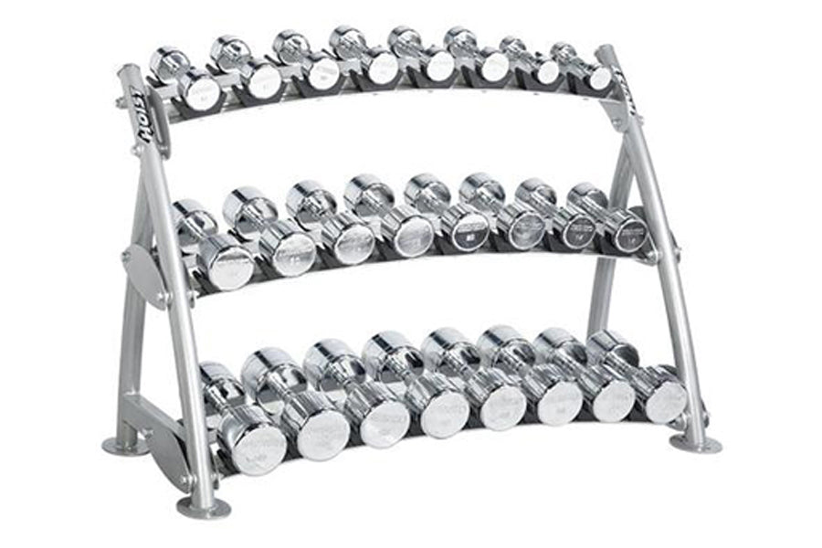 Three-tier gray metal dumbbell rack with chrome saddle holders displaying multiple pairs of chrome dumbbells on white backgro