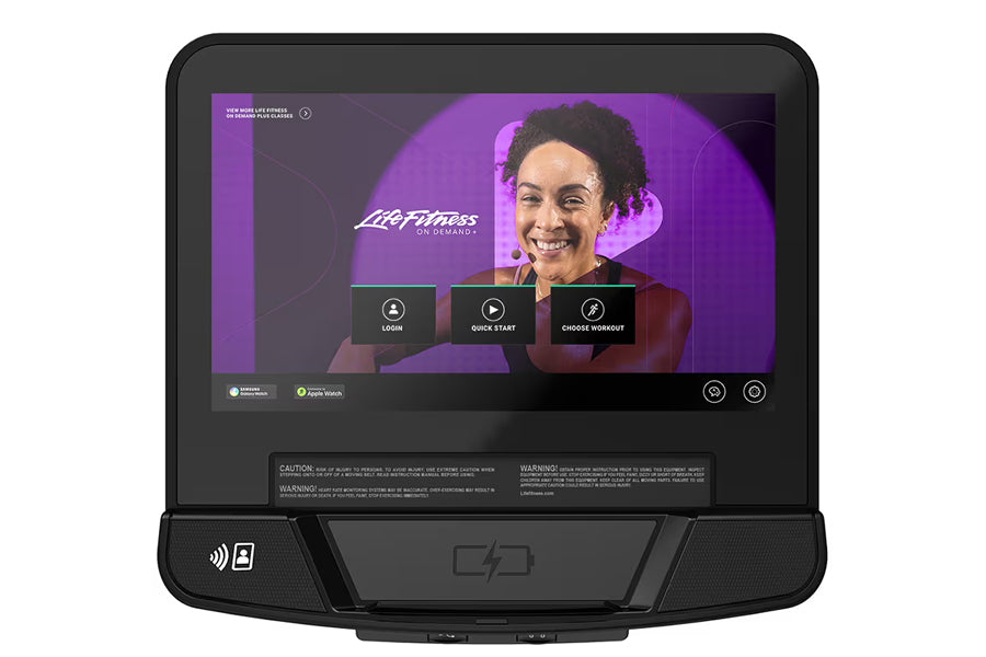 Life Fitness Club Series+ upright exercise bike with touchscreen display showing workout interface and smiling instructor, bl