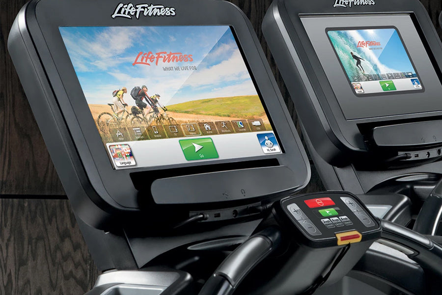 Life Fitness Platinum Club Series exercise machine with touchscreen display showing cycling workout scene and control console