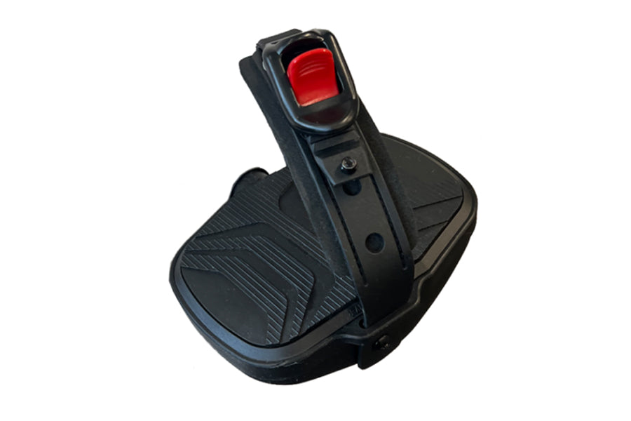Black recumbent exercise bike foot pedal with red button and textured grip pad on white background