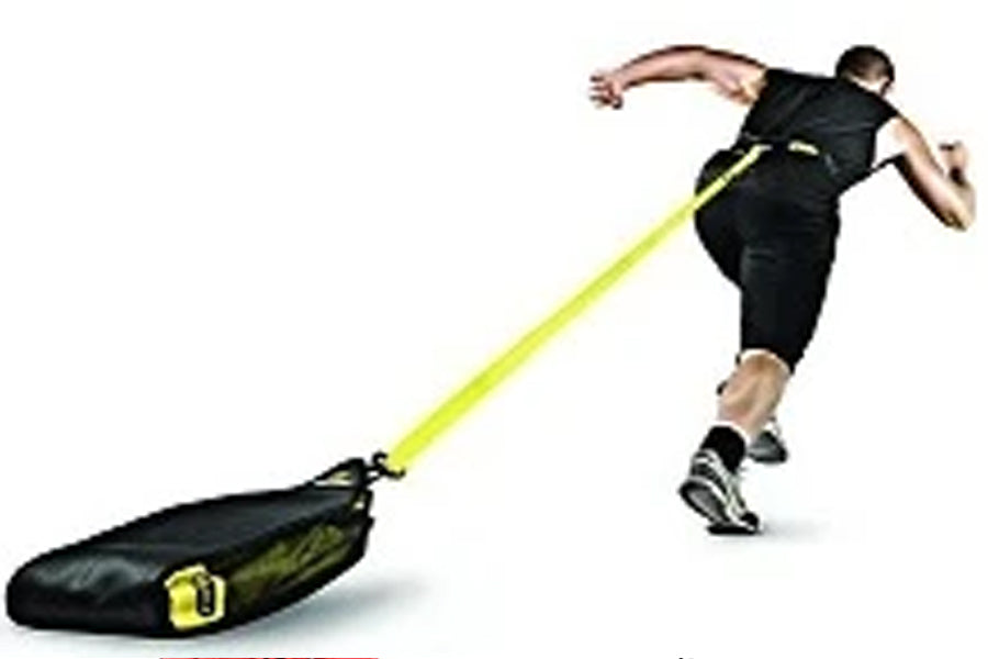 Male athlete in black sleeveless tank and shorts using black and neon yellow resistance training sled in dynamic sprinting mo