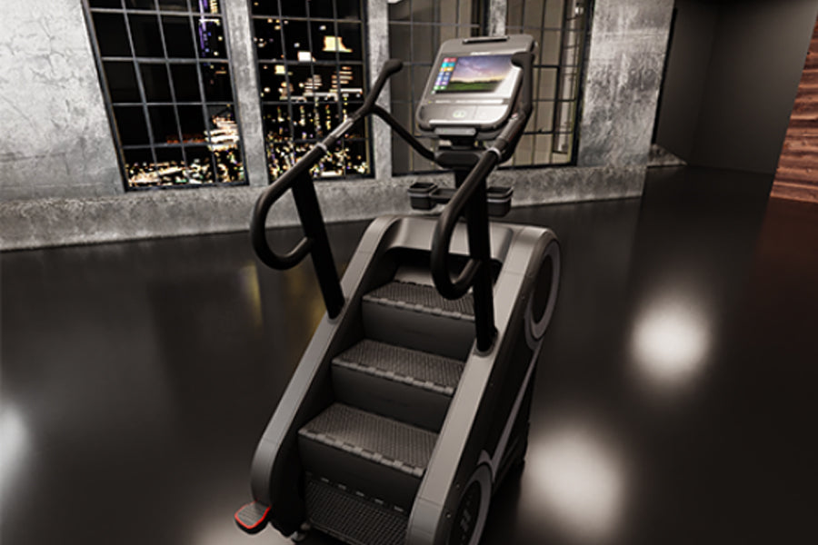 Black and silver StairMaster 8Gx stair stepper with dual handles and digital display screen in gym setting