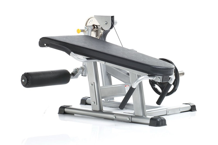 TuffStuff Evolution plate load leg extension and prone leg curl bench with silver metal frame, black padded seat and backrest