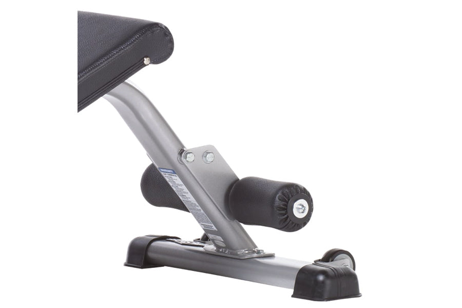Gray and black compact ab bench with padded seat, adjustable leg extension, and stabilizing feet on white background