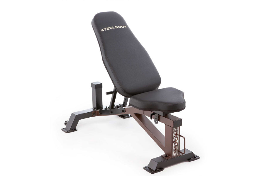 Steelbody dark gray adjustable weight bench with padded backrest and seat, brown metal frame with leg extension attachment, o