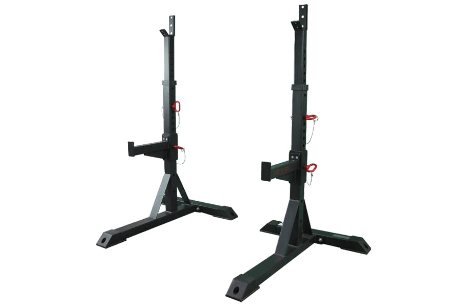 Pair of black steel squat stands with adjustable J-cups, red safety pins, and wide foot bases, shown on white background