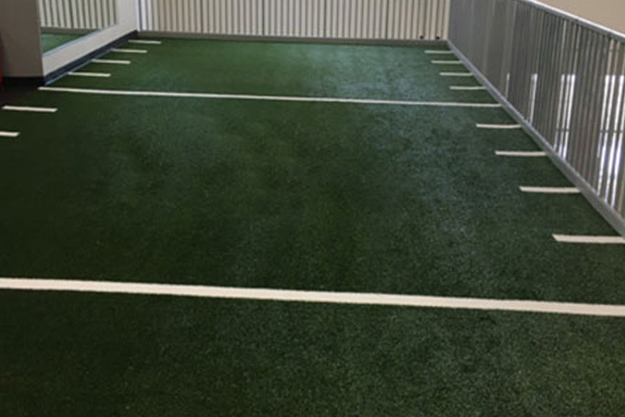 Warrior Agility Turf synthetic grass field with white yard line markings and metal fencing