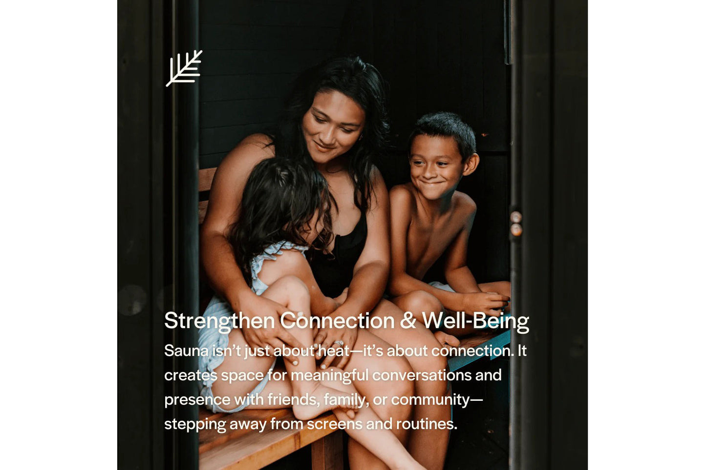 Woman and two children sitting together inside wooden sauna cabin with dark interior