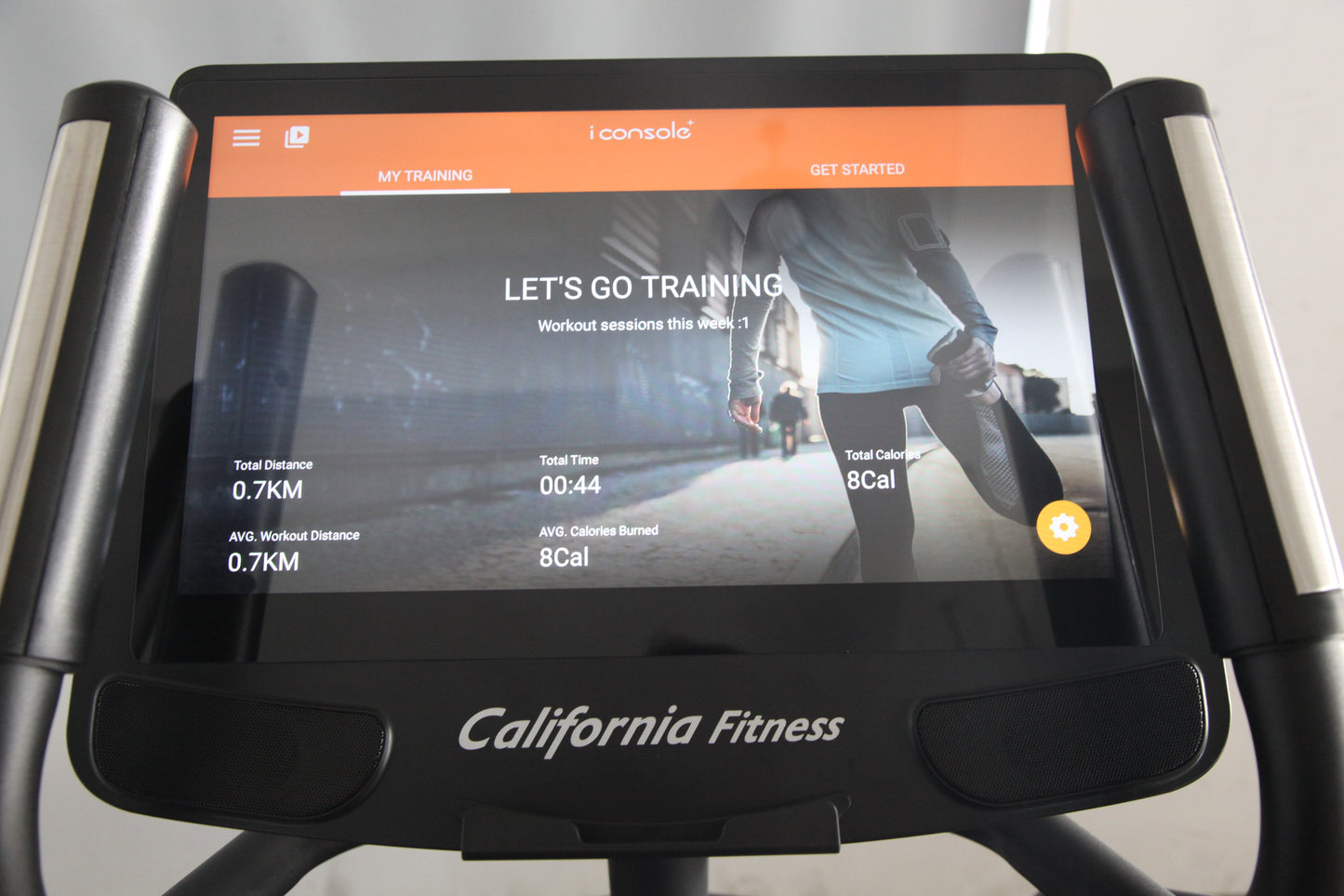 California Fitness E8i elliptical machine with black frame and silver handles, displaying iConsole training app screen showin