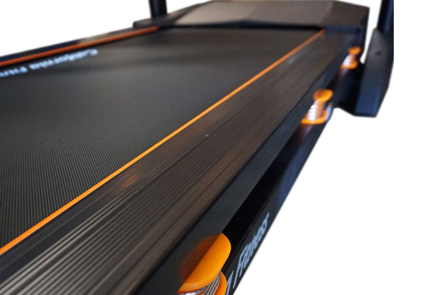 Black folding treadmill with orange trim and accents, featuring textured running belt and side controls, shown on white backg