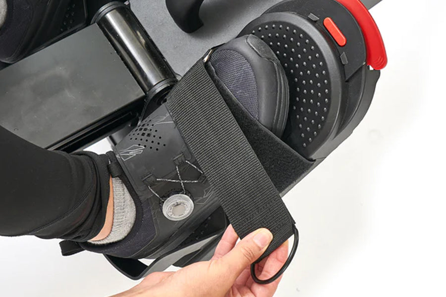 Gaming headset with black and gray ear cups, perforated padding, and red accents, held in hand against white background