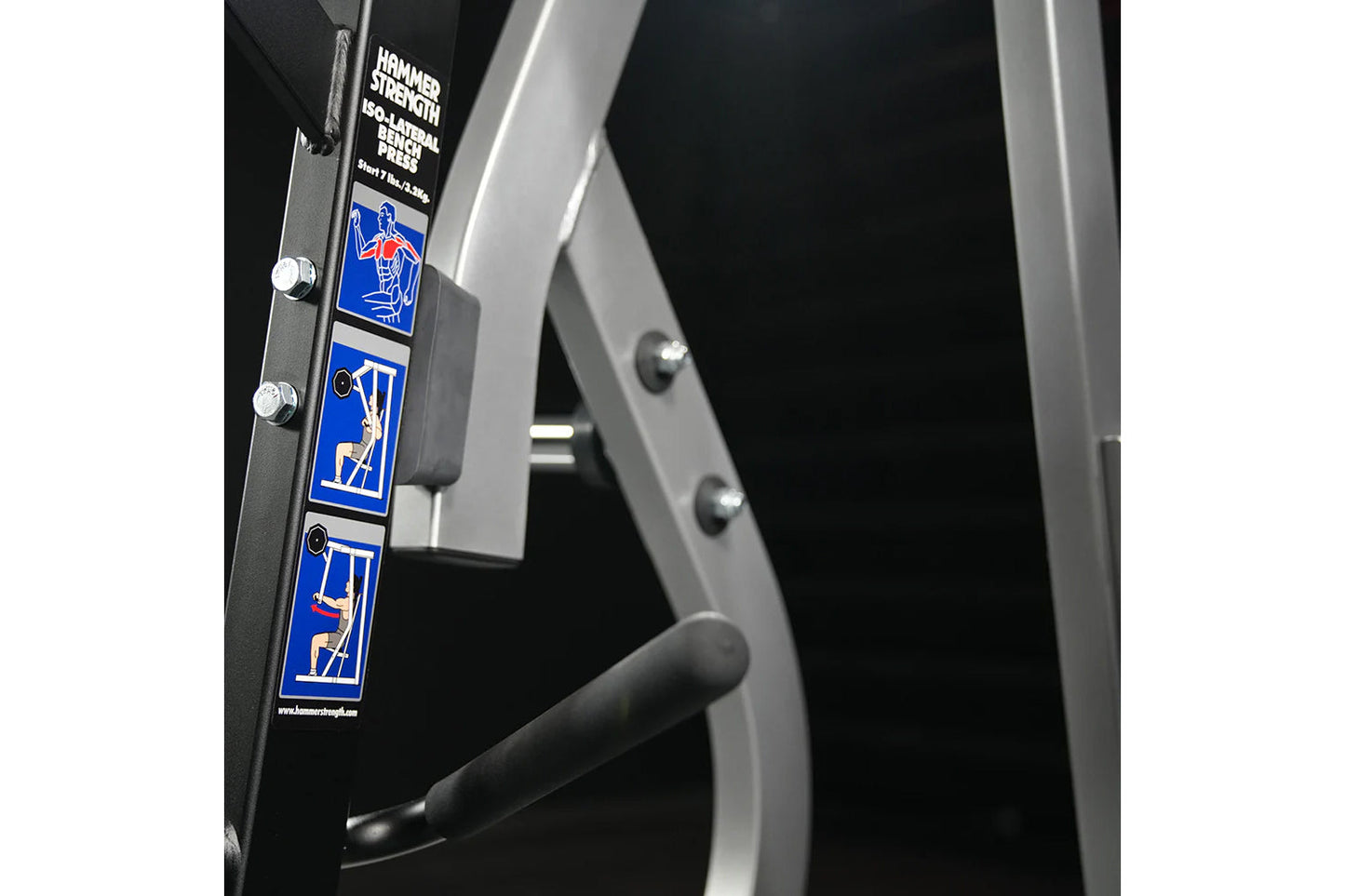 Hammer Strength plate-loaded iso-lateral bench press with black frame, silver accents, and blue instructional decals showing