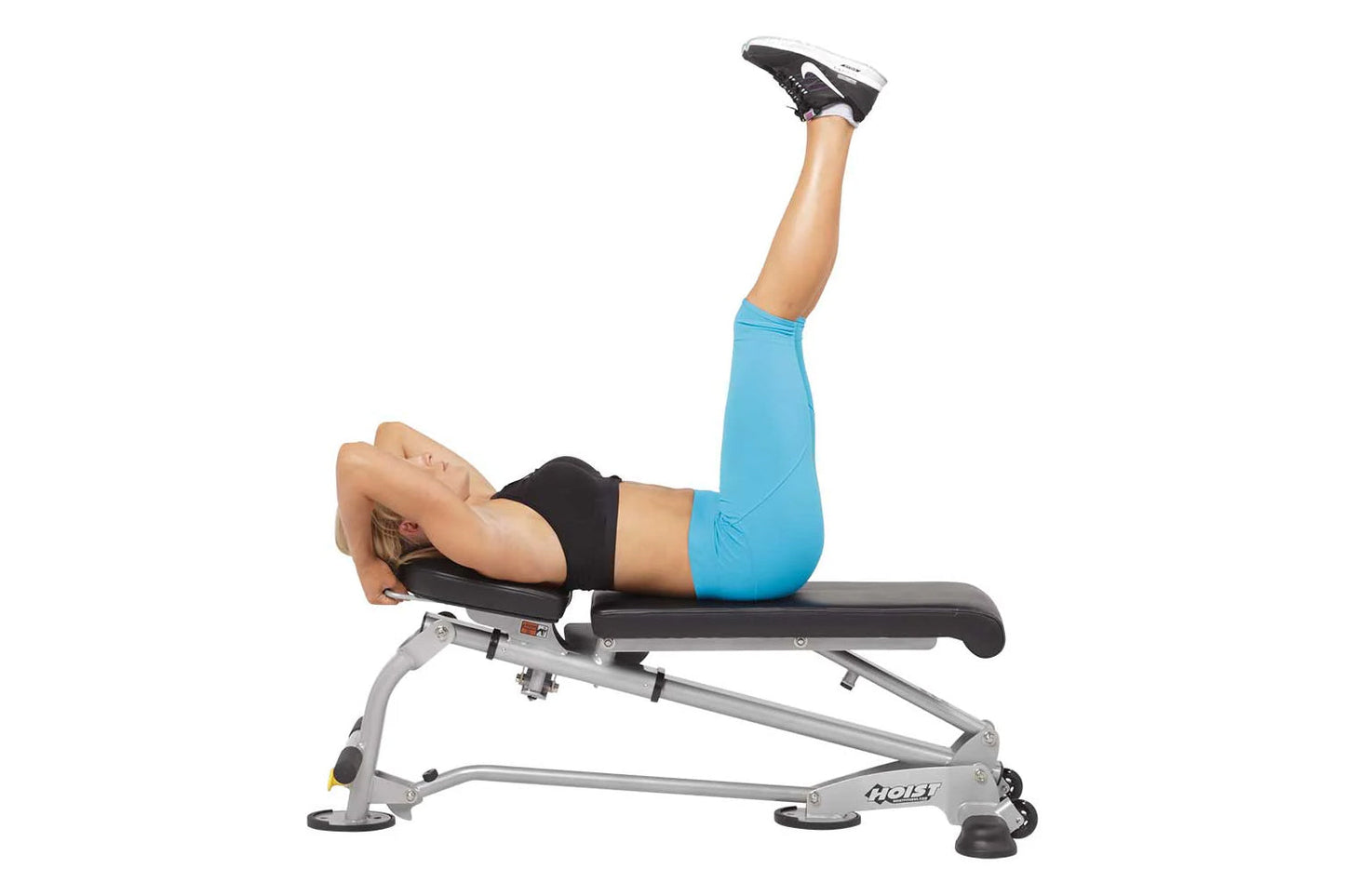 Model performing leg raise exercise on Hoist 7-Position Folding Fid Bench, wearing blue leggings and black sports bra with bl