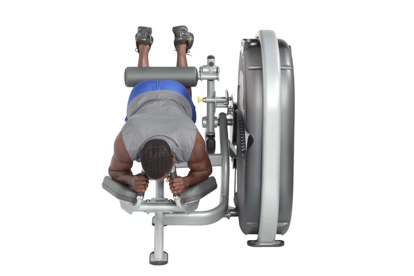 Person using gray and silver leg curl machine with large weighted plate, wearing blue headband and gray shirt, viewed from ab