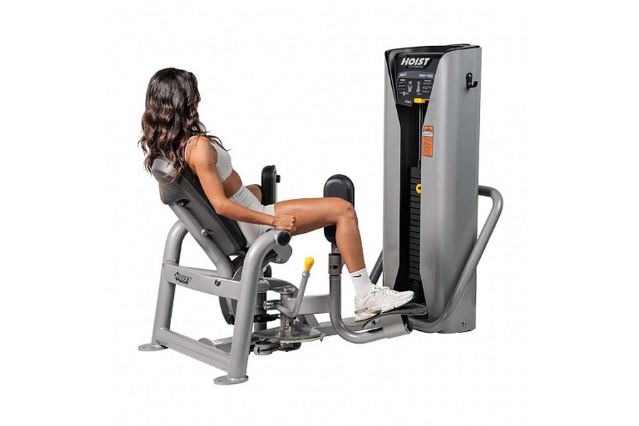 Hoist ROC-IT leg press machine with gray frame and black seat, shown with model demonstrating use on white background