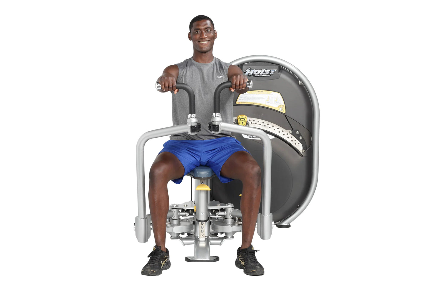 Man using gray Hoist pec fly machine with blue shorts, demonstrating chest exercise on white background