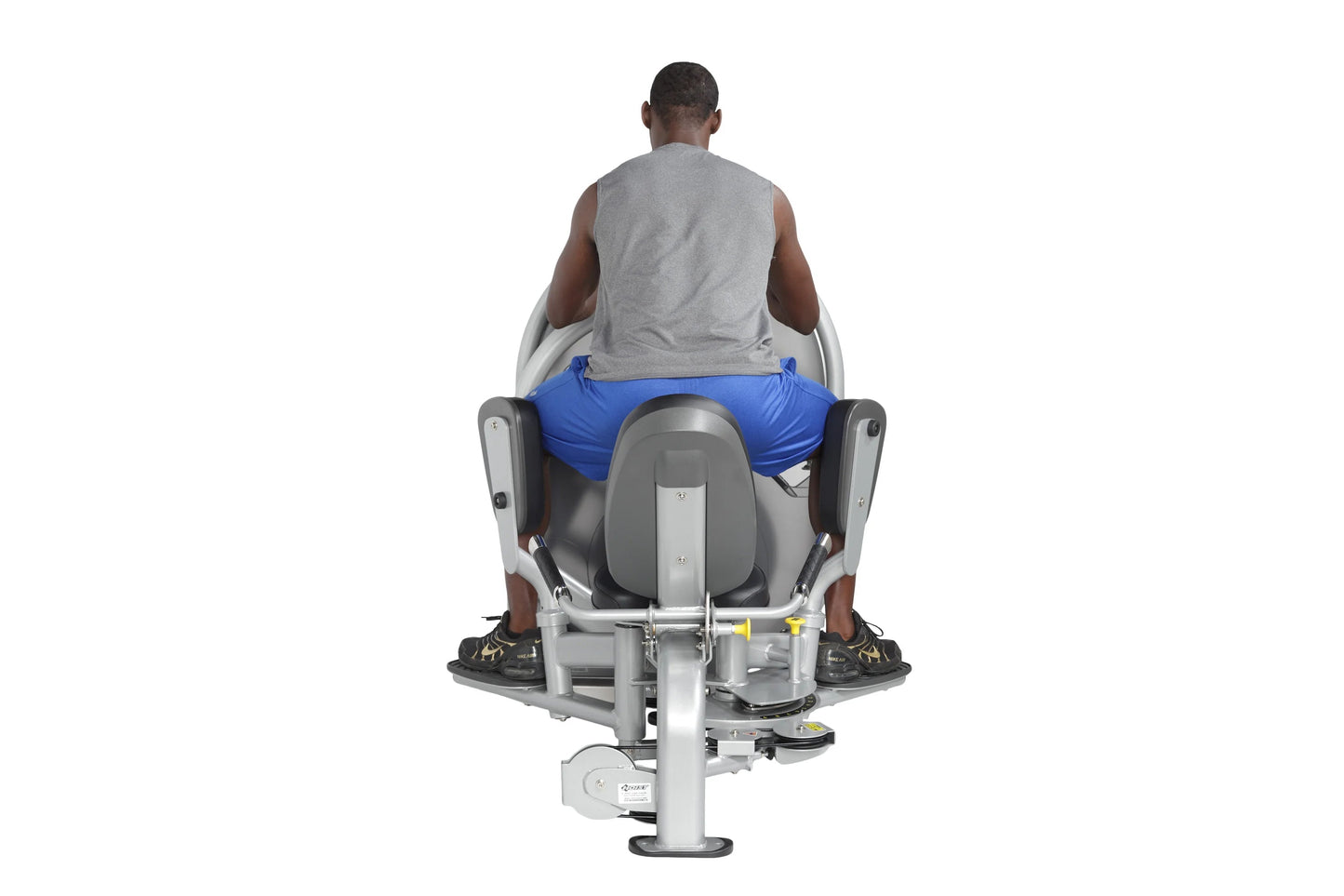 Man seated on gray and blue leg press machine viewed from behind, demonstrating proper thigh exercise form