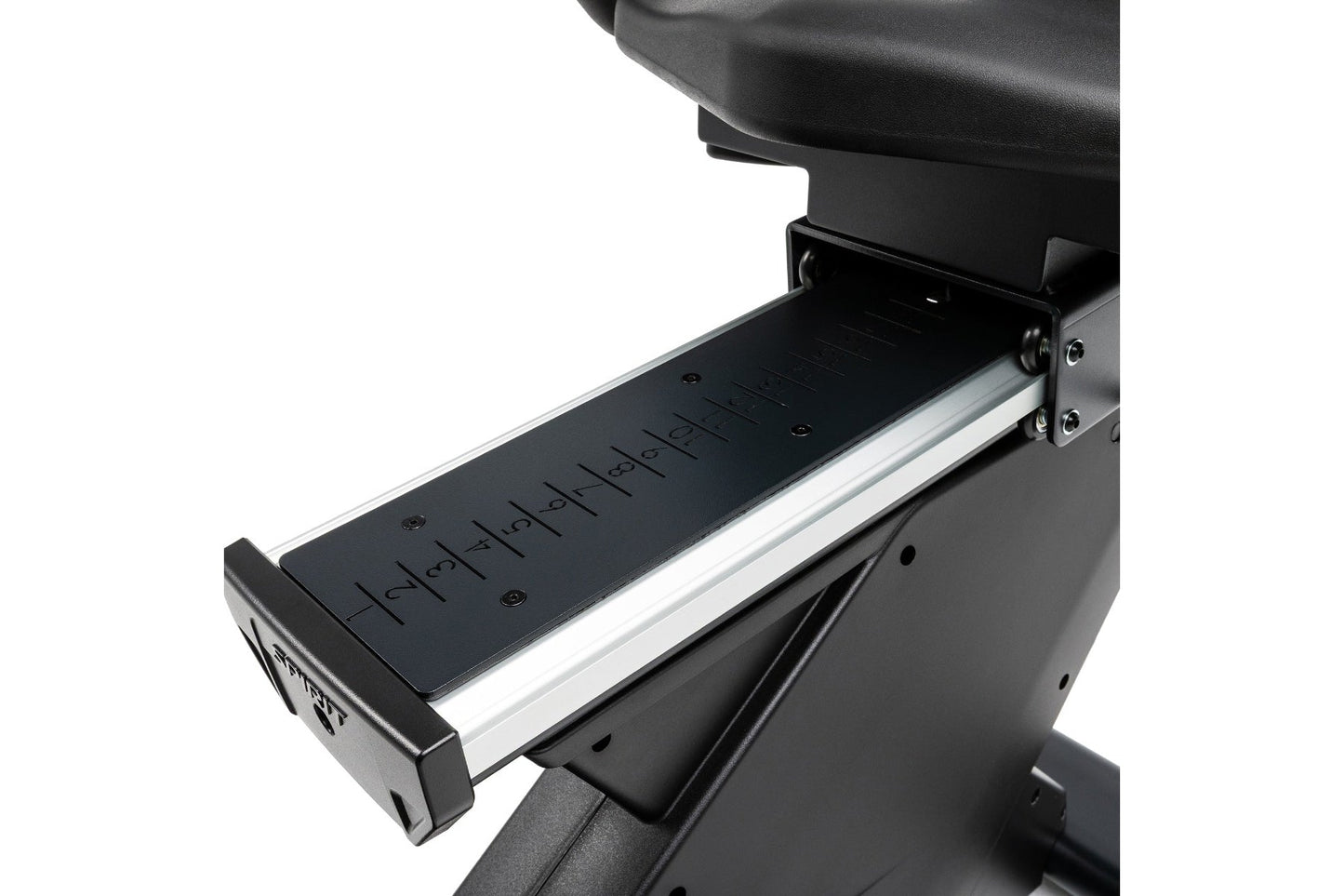Black recumbent exercise bike with extended foot pedal platform, numbered measurement markings, and silver aluminum frame det