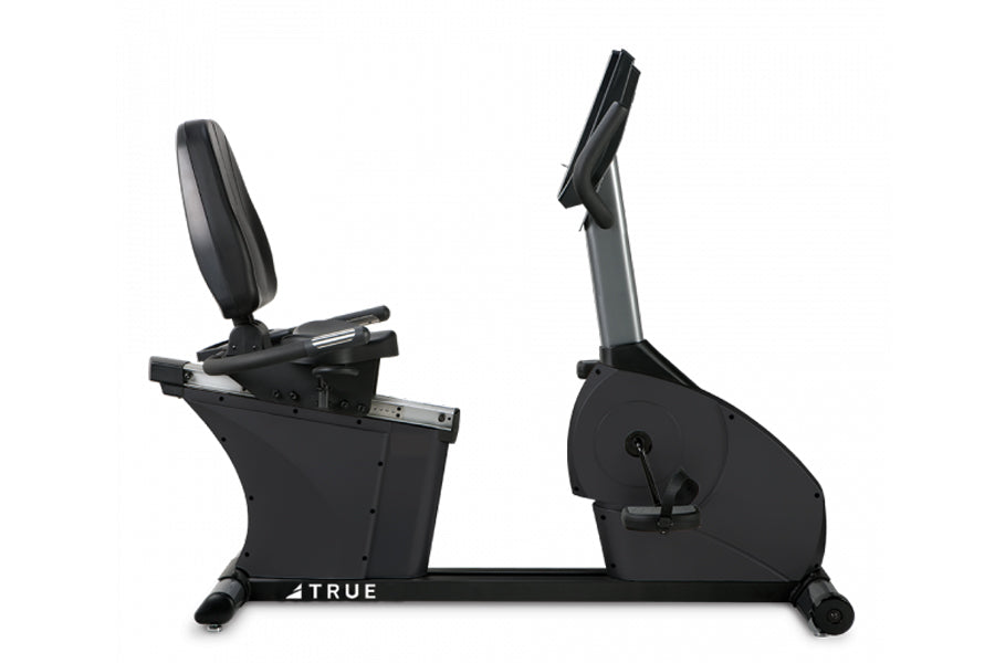 Black recumbent stationary bike with padded backrest, grey upright support, foot pedals, and digital console, shown on white 