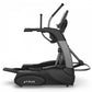 Black and gray commercial elliptical machine with dual handles, foot pedals, and digital console display on white background
