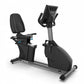 Black and gray TRUE commercial recumbent exercise bike with padded seat, digital console, and adjustable handlebars on white 