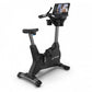 TRUE CS400 black upright exercise bike with gray frame, digital display console, and foot pedals on white background