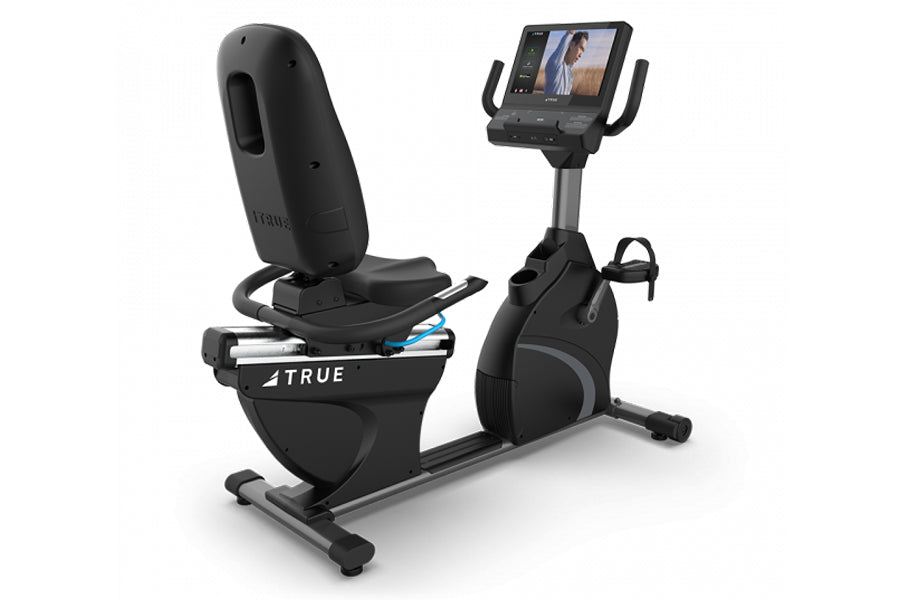 Black recumbent exercise bike with digital display console, padded seat, foot pedals, and handle grips, isolated on white bac