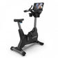 TRUE 900 upright exercise bike with black frame, gray column, padded seat, and digital display console on white background