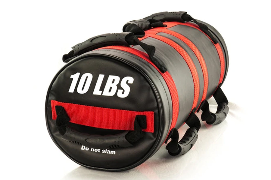 Black and red cylindrical sandbag labeled 10 LBS with carrying handles and reinforced stitching, displayed on white backgroun