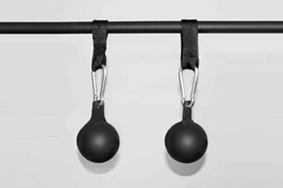 Pair of black spherical pull-up grip balls with rubber handles hanging from black metal bar