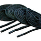 Black twisted battle ropes coiled with four extended strands on white background