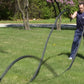 Man using black battle ropes for outdoor fitness training on grass