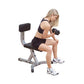 Woman performing dumbbell exercise on gray and black utility bench with leg extension attachment