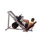Body-Solid leg press and hack squat machine with gray frame and black weight plates, demonstrated by man in yellow tank top o