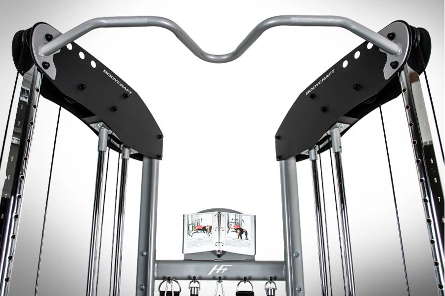 BodyCraft HFT functional trainer with gray curved bar and black weight plates, viewed from front on white background