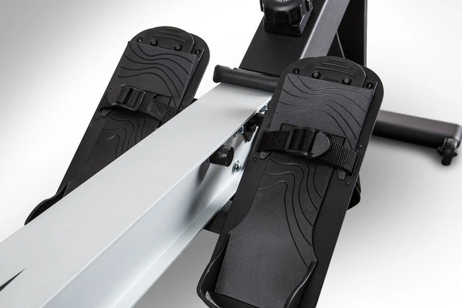 BodyCraft VR400 Pro rowing machine with silver frame and black foot pedals with textured grip straps on white background