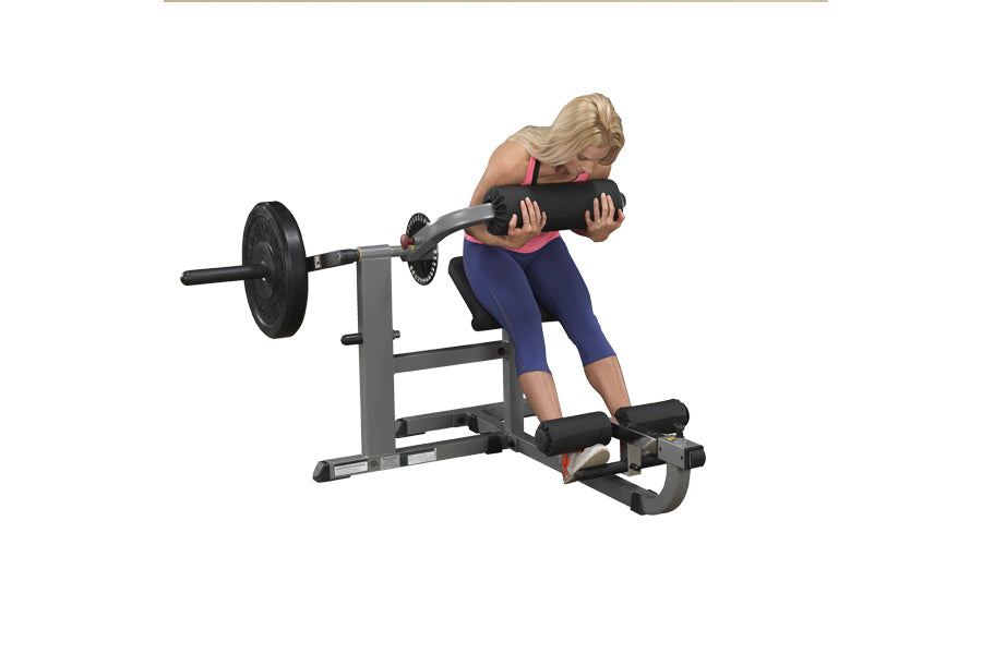 Woman using gray and black leg press ab and back exercise machine with weighted plate on white background