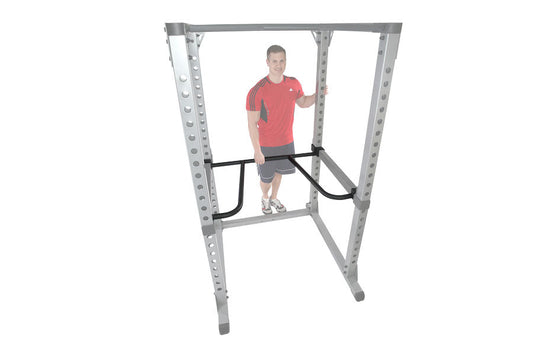 Man in red shirt and gray shorts using silver and black dip bar attachment mounted on weight rack frame