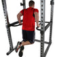 Man wearing red t-shirt and black shorts using dip bars on Body-Solid power rack with white background