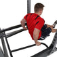 Man wearing red shirt and black shorts using dip attachment on gray metal weight rack against white background