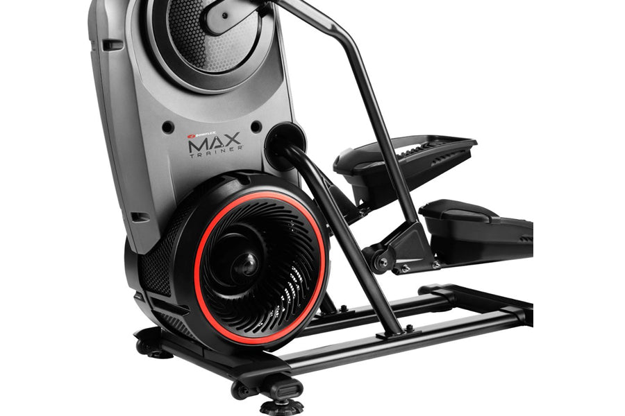 Bowflex Max Trainer M9 elliptical machine with black frame, red-accented flywheel, gray console, and dual foot pedals on whit