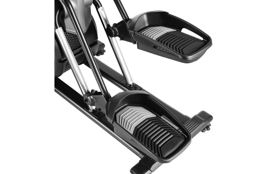 Black and silver elliptical trainer with dual foot pedals and upper body handles, shown at angle on white background