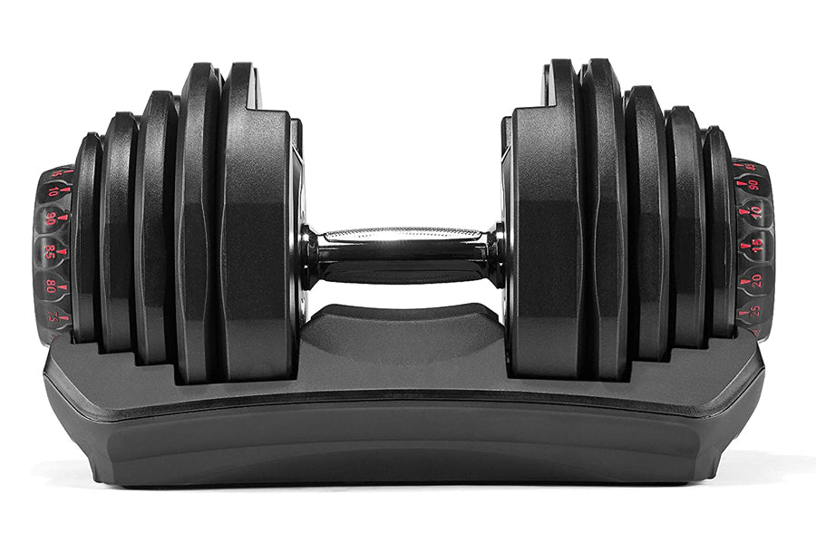 Bowflex SelectTech adjustable dumbbell with black weight plates and red numbered dial, resting on gray base, front view