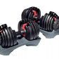 Pair of black Bowflex SelectTech dumbbells with red adjustment handles and weight selector dials, displayed on gray base tray