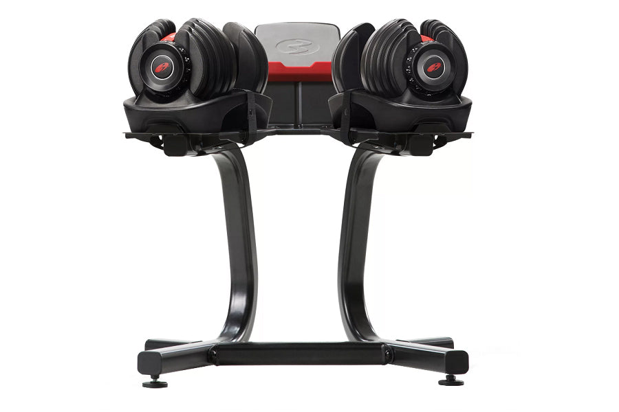 Pair of black Bowflex SelectTech dumbbells with red accents on stand, featuring adjustable weight dial, on white background