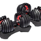 Pair of black adjustable dumbbells with red handles and weight plates on matching black stand with white background