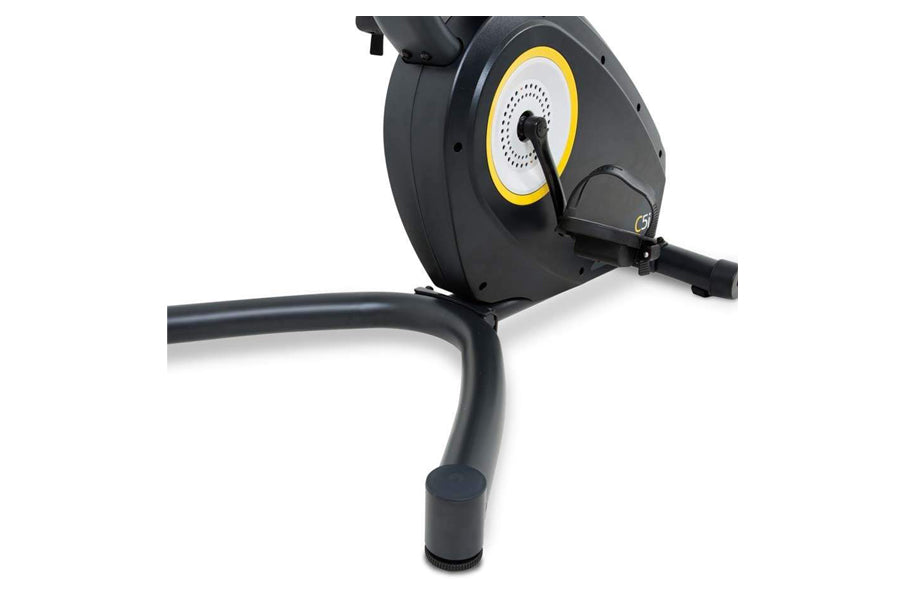 Black upright exercise bike with yellow and white flywheel, shown at angle on white background