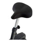 Black cushioned seat with silver metal post on upright exercise bike, isolated on white background