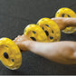 SKLZ COREwheels yellow core training wheels with ventilation holes held in hands on dark mat